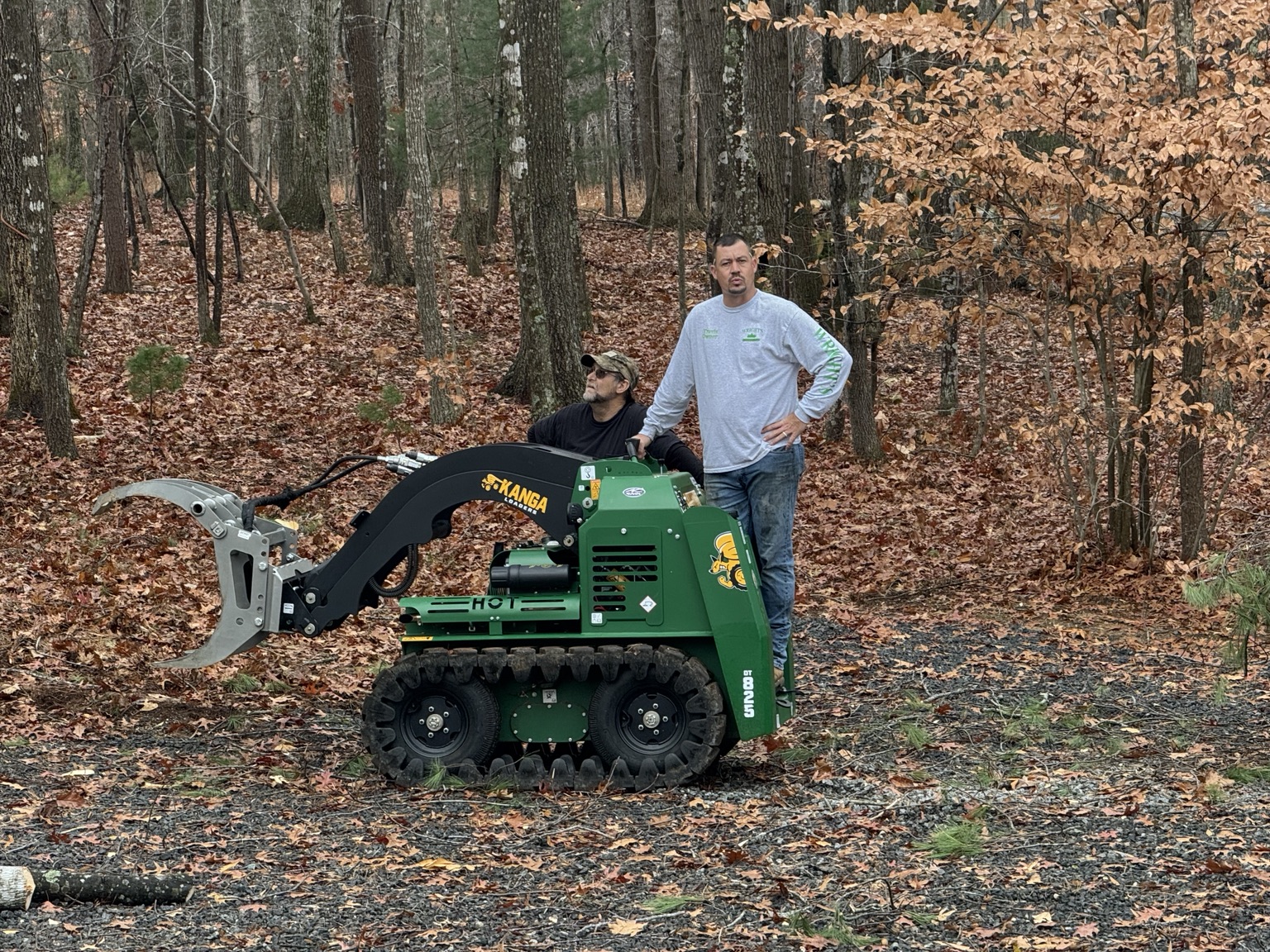 Travis and Andy Wright with equipment at a wooded job site